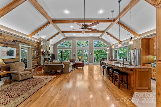 429 Turtle Head Dr, Nebo, NC 28761 - living room featuring a ceiling fan, light wood-style floors, a stone fireplace, beam ceiling, and wooden walls