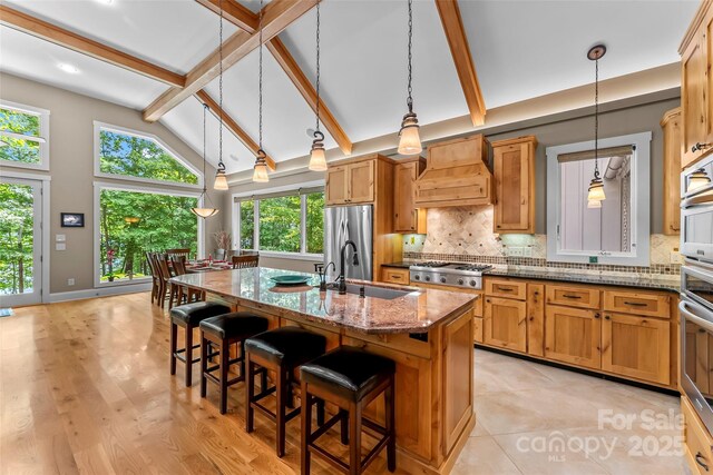 429 Turtle Head Dr, Nebo, NC 28761 - kitchen featuring custom range hood, beam ceiling, decorative backsplash, dark stone countertops, and appliances with stainless steel finishes