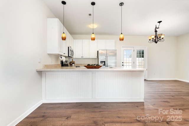 28 Ridgestone Cir, Mauldin, SC 29662 - kitchen with appliances with stainless steel finishes, a peninsula, wood finished floors, light countertops, and white cabinetry