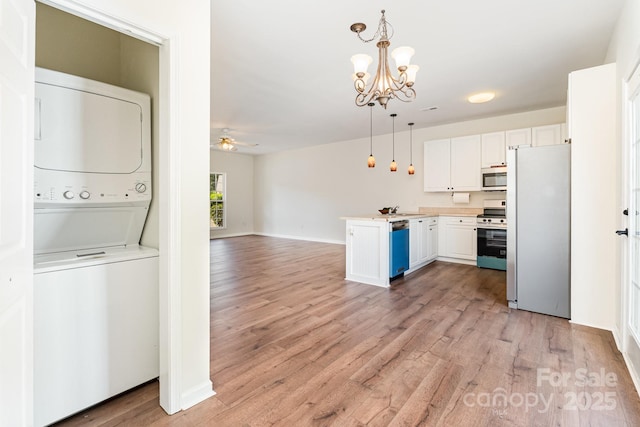28 Ridgestone Cir, Mauldin, SC 29662 - kitchen featuring appliances with stainless steel finishes, stacked washing machine and dryer, a ceiling fan, white cabinets, and a chandelier