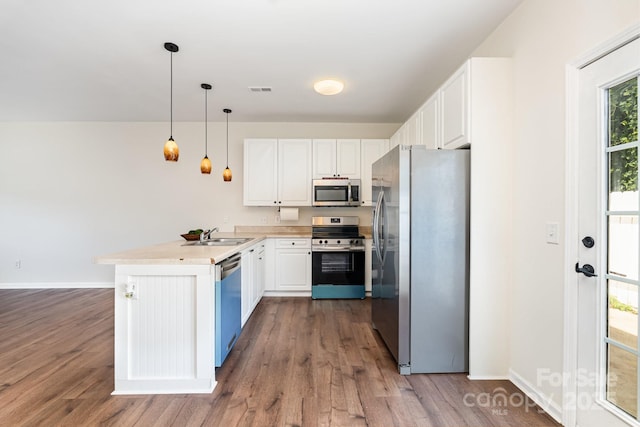 28 Ridgestone Cir, Mauldin, SC 29662 - kitchen featuring appliances with stainless steel finishes, a peninsula, white cabinetry, dark wood-type flooring, and light countertops