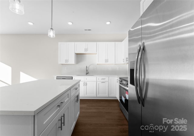 7300 Boswell Rd Unit 4A, Charlotte, NC 28215 - kitchen with appliances with stainless steel finishes, light countertops, dark wood-type flooring, white cabinetry, and pendant lighting