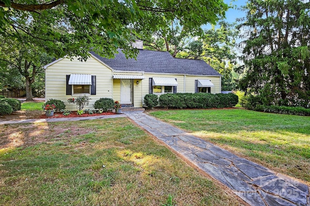 422 Wagner St, Troutman, NC 28166 - bungalow-style home with a front yard, a chimney, and a shingled roof