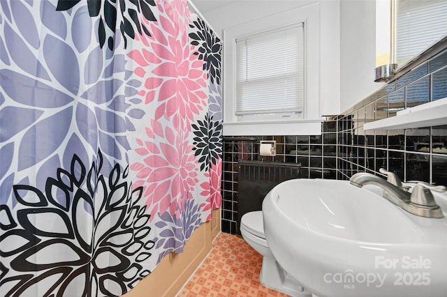 422 Wagner St, Troutman, NC 28166 - full bath with radiator heating unit, tile walls, wainscoting, tile patterned floors, and shower / bath combination with curtain