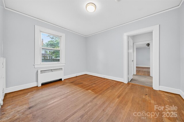 422 Wagner St, Troutman, NC 28166 - spare room featuring radiator heating unit, light wood-style flooring, and ornamental molding