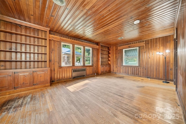 422 Wagner St, Troutman, NC 28166 - empty room with radiator, healthy amount of natural light, wooden ceiling, wooden walls, and wood-type flooring