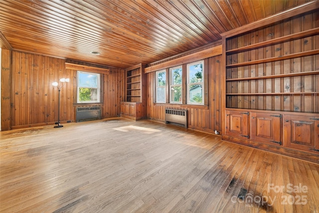 422 Wagner St, Troutman, NC 28166 - unfurnished room with radiator heating unit, wood walls, wood ceiling, and hardwood / wood-style floors