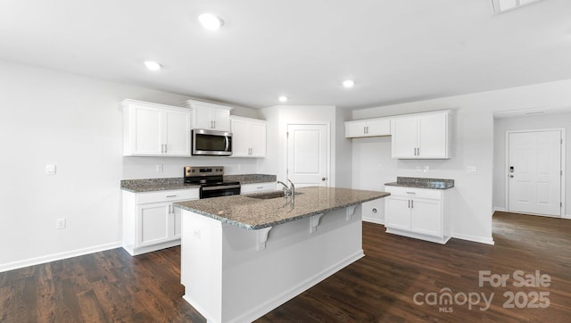 462 Janie Cir Unit 100, Newton, NC 28658 - kitchen with stainless steel appliances, dark stone countertops, a center island with sink, dark wood-style floors, and white cabinets