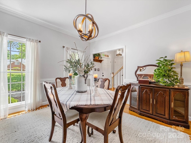 11126 Windgate Ct, Tega Cay, SC 29708 - dining room featuring a chandelier, crown molding, light wood-style floors, a wainscoted wall, and stairway