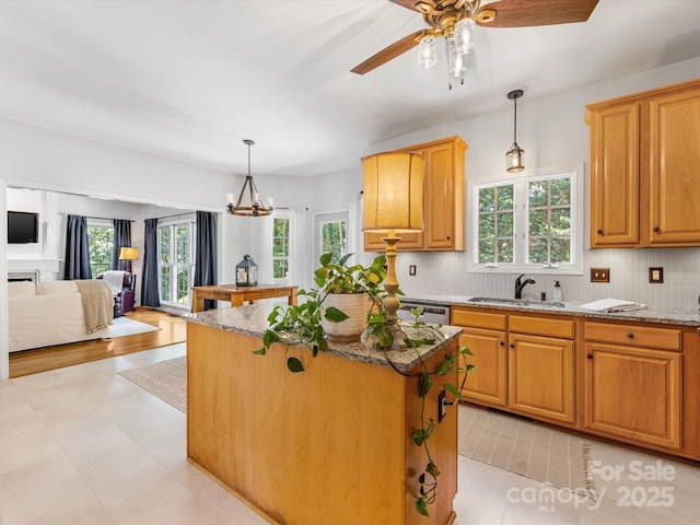 11126 Windgate Ct, Tega Cay, SC 29708 - kitchen featuring a kitchen island, light stone countertops, tasteful backsplash, a chandelier, and a ceiling fan