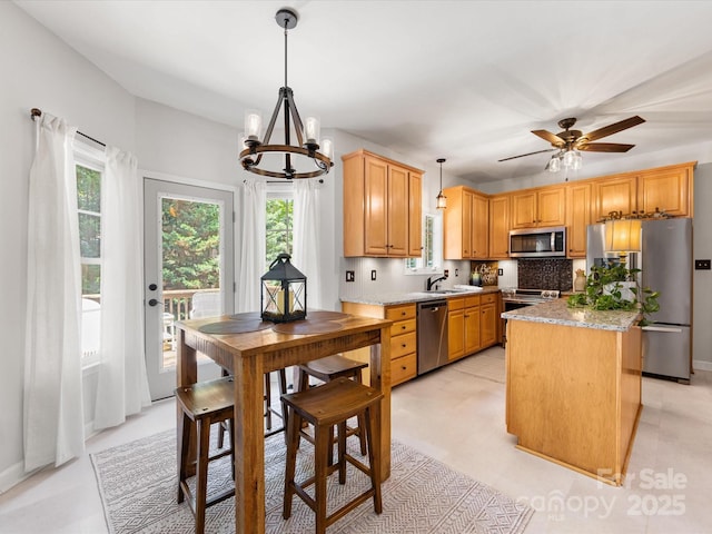 11126 Windgate Ct, Tega Cay, SC 29708 - kitchen featuring stainless steel appliances, a chandelier, a kitchen island, hanging light fixtures, and light countertops