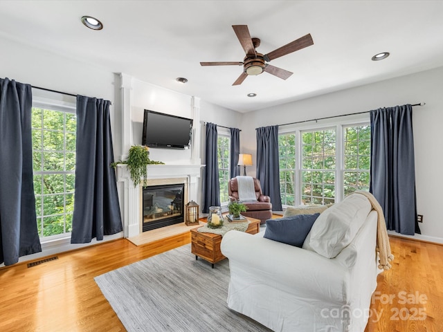 11126 Windgate Ct, Tega Cay, SC 29708 - living room featuring a ceiling fan, a glass covered fireplace, recessed lighting, and light wood-style floors