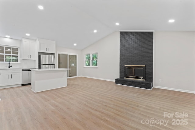 5534 Great Wagon Rd, Charlotte, NC 28215 - unfurnished living room featuring light wood-style flooring, a fireplace, recessed lighting, and vaulted ceiling