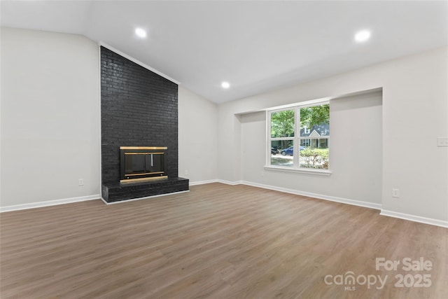 5534 Great Wagon Rd, Charlotte, NC 28215 - unfurnished living room featuring vaulted ceiling, wood finished floors, a fireplace, and recessed lighting