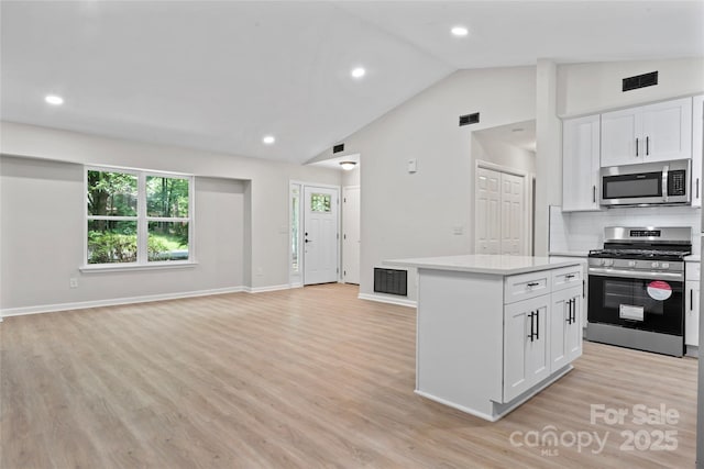 5534 Great Wagon Rd, Charlotte, NC 28215 - kitchen with stainless steel appliances, open floor plan, light countertops, white cabinets, and vaulted ceiling