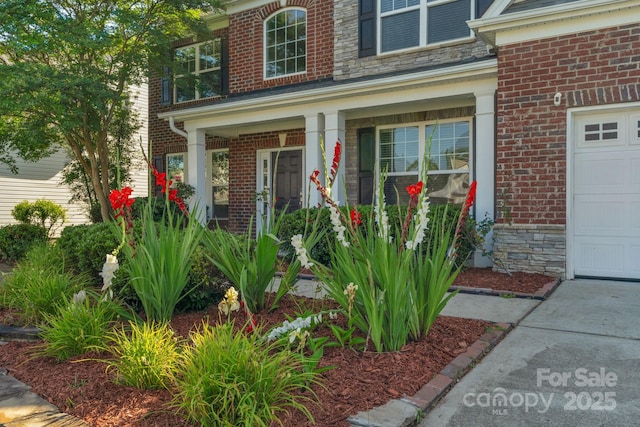 8325 Burgundy Ridge Dr, Harrisburg, NC 28075 - property entrance featuring covered porch, brick siding, and stone siding