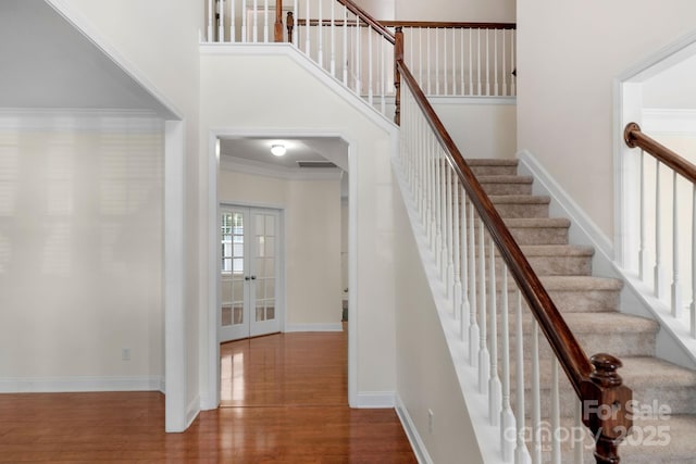 8325 Burgundy Ridge Dr, Harrisburg, NC 28075 - stairs with wood finished floors, ornamental molding, and a towering ceiling