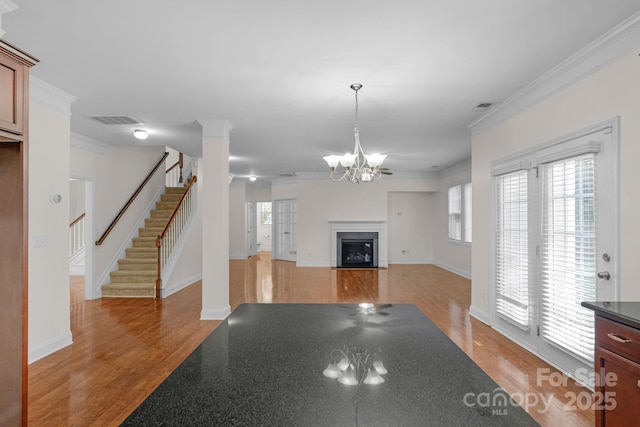 8325 Burgundy Ridge Dr, Harrisburg, NC 28075 - unfurnished living room featuring light wood-style flooring, healthy amount of natural light, stairs, and ornamental molding
