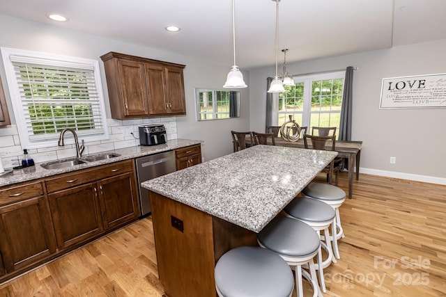 1005 8th Ave SW, Conover, NC 28613 - kitchen featuring stainless steel dishwasher, light wood-style flooring, a kitchen bar, tasteful backsplash, and recessed lighting