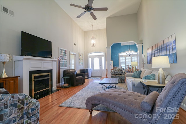 406 Spyglass Hill Pl, Salisbury, NC 28144 - living area featuring a towering ceiling, a chandelier, ceiling fan, a fireplace with flush hearth, and wood finished floors