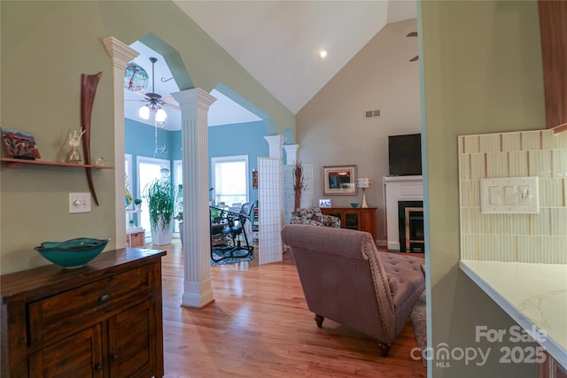 406 Spyglass Hill Pl, Salisbury, NC 28144 - living room featuring high vaulted ceiling, decorative columns, light wood-style flooring, a fireplace, and ceiling fan
