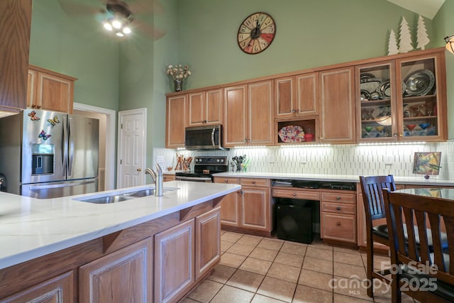 406 Spyglass Hill Pl, Salisbury, NC 28144 - kitchen featuring stainless steel appliances, high vaulted ceiling, decorative backsplash, light tile patterned floors, and glass insert cabinets