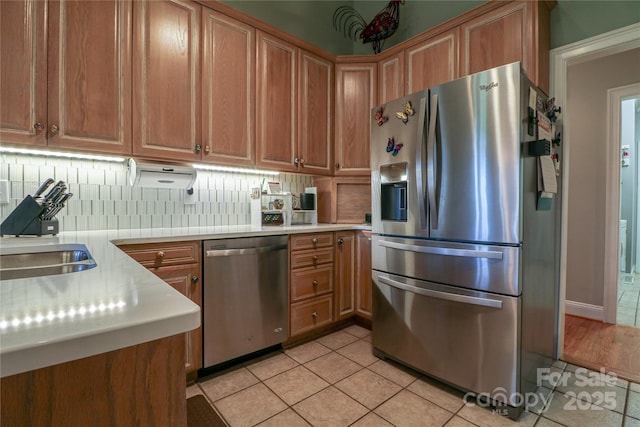 406 Spyglass Hill Pl, Salisbury, NC 28144 - kitchen featuring appliances with stainless steel finishes, light countertops, decorative backsplash, light tile patterned floors, and brown cabinets