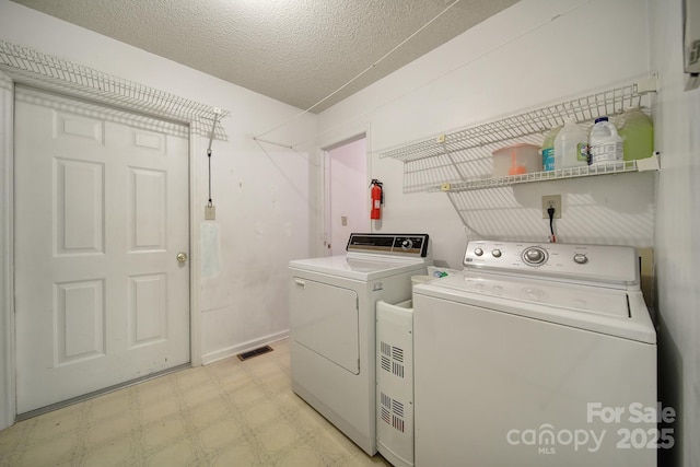 8416 Rittenhouse Cir, Charlotte, NC 28270 - laundry room with washing machine and clothes dryer, light floors, and a textured ceiling