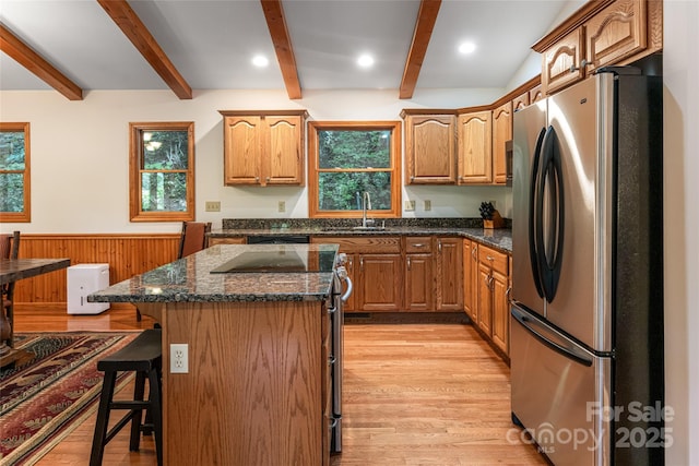 380 Allison Dr, Maggie Valley, NC 28751 - kitchen featuring appliances with stainless steel finishes, beamed ceiling, a breakfast bar area, light wood finished floors, and dark stone countertops