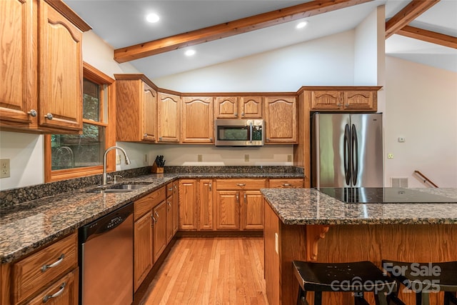 380 Allison Dr, Maggie Valley, NC 28751 - kitchen with appliances with stainless steel finishes, light wood-style flooring, a breakfast bar, dark stone counters, and brown cabinets