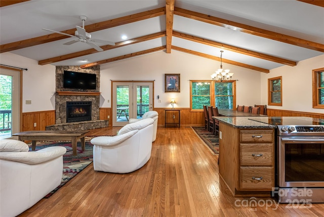 380 Allison Dr, Maggie Valley, NC 28751 - living area with wainscoting, light wood-style floors, a stone fireplace, healthy amount of natural light, and wooden walls