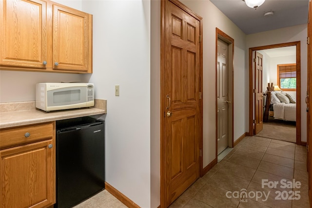 380 Allison Dr, Maggie Valley, NC 28751 - kitchen with fridge, white microwave, light countertops, and tile patterned flooring