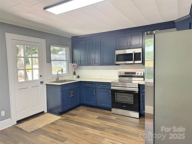 201 Barnes Ln, Stony Point, NC 28678 - kitchen with appliances with stainless steel finishes, light countertops, blue cabinetry, and wood finished floors
