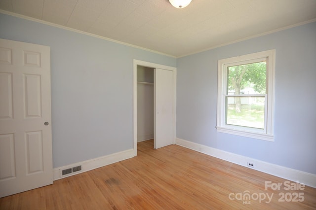 7645 Robinson Church Rd, Harrisburg, NC 28075 - unfurnished bedroom featuring crown molding, light wood-style floors, and a closet