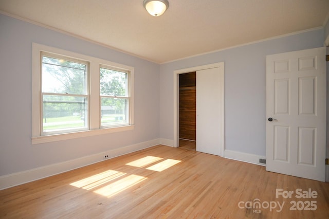 7645 Robinson Church Rd, Harrisburg, NC 28075 - unfurnished bedroom with crown molding, light wood-type flooring, and a closet