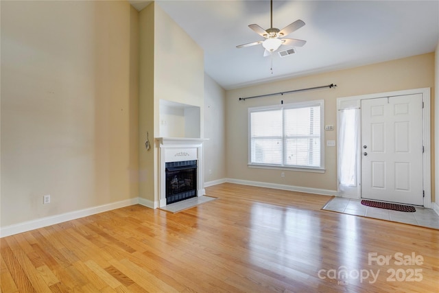 2785 Clover Rd NW, Concord, NC 28027 - unfurnished living room with vaulted ceiling, a fireplace with flush hearth, a ceiling fan, and light wood-type flooring