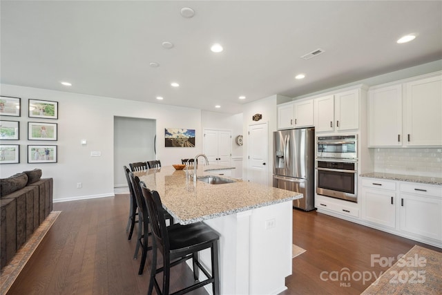 13339 Mcguffy Dr, Huntersville, NC 28078 - kitchen with appliances with stainless steel finishes, dark wood-style floors, white cabinets, tasteful backsplash, and recessed lighting