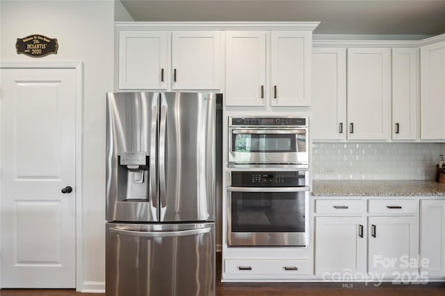 13339 Mcguffy Dr, Huntersville, NC 28078 - kitchen featuring stainless steel appliances, light stone counters, white cabinets, and tasteful backsplash