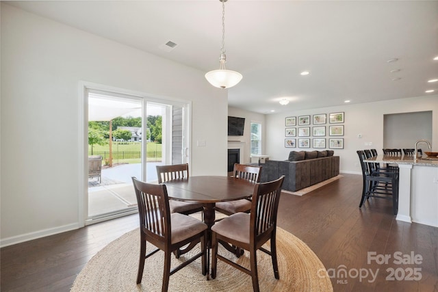 13339 Mcguffy Dr, Huntersville, NC 28078 - dining area with dark wood finished floors, recessed lighting, and a fireplace