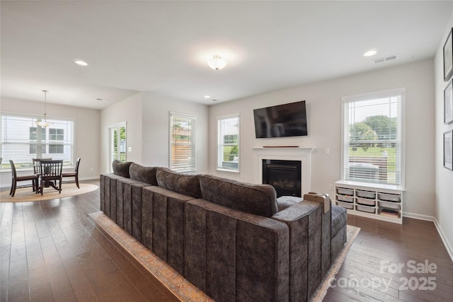 13339 Mcguffy Dr, Huntersville, NC 28078 - living area with a glass covered fireplace, healthy amount of natural light, dark wood-style floors, and recessed lighting