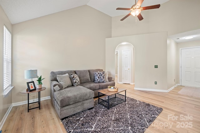 121 Gilcrest Ln, Troutman, NC 28166 - living room featuring arched walkways, high vaulted ceiling, ceiling fan, light wood-style flooring, and healthy amount of natural light