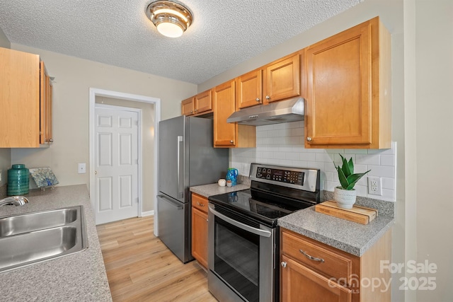 121 Gilcrest Ln, Troutman, NC 28166 - kitchen featuring stainless steel appliances, under cabinet range hood, light wood finished floors, decorative backsplash, and a textured ceiling