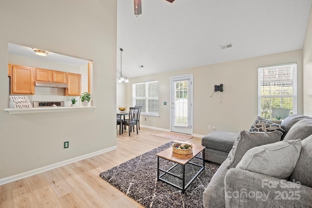 121 Gilcrest Ln, Troutman, NC 28166 - living room with light wood-style flooring, a chandelier, and a ceiling fan