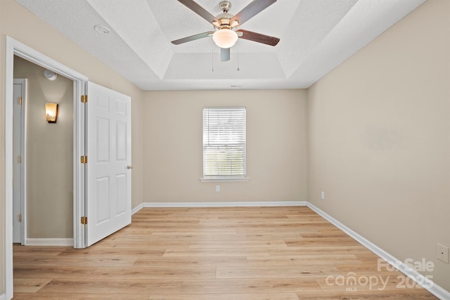 121 Gilcrest Ln, Troutman, NC 28166 - empty room with a raised ceiling, a ceiling fan, and light wood finished floors