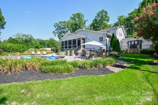 711 Yadkin St, Albemarle, NC 28001 - rear view of house with a sunroom, a patio, and an outdoor pool
