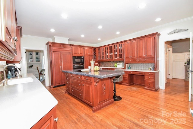 711 Yadkin St, Albemarle, NC 28001 - kitchen with black appliances, a kitchen bar, crown molding, decorative backsplash, and a center island