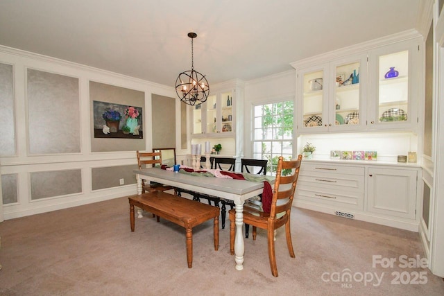 711 Yadkin St, Albemarle, NC 28001 - dining area with a chandelier, ornamental molding, light colored carpet, and a decorative wall