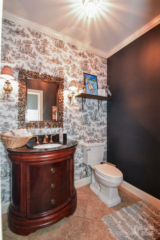 711 Yadkin St, Albemarle, NC 28001 - half bath featuring wallpapered walls, ornamental molding, vanity, and tile patterned flooring