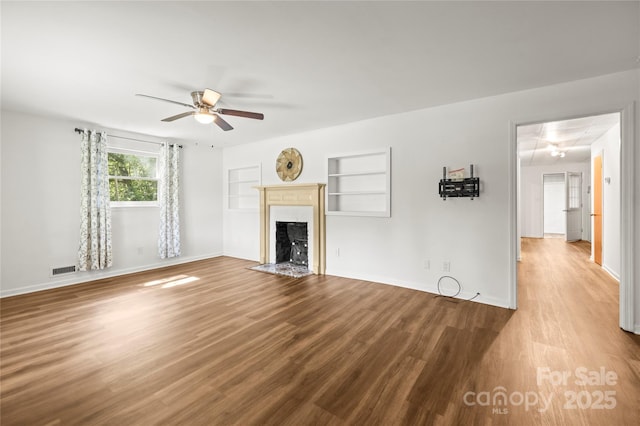 2028 Old Latter Rd, Newton, NC 28658 - unfurnished living room with a ceiling fan, wood finished floors, a fireplace with flush hearth, and attic access