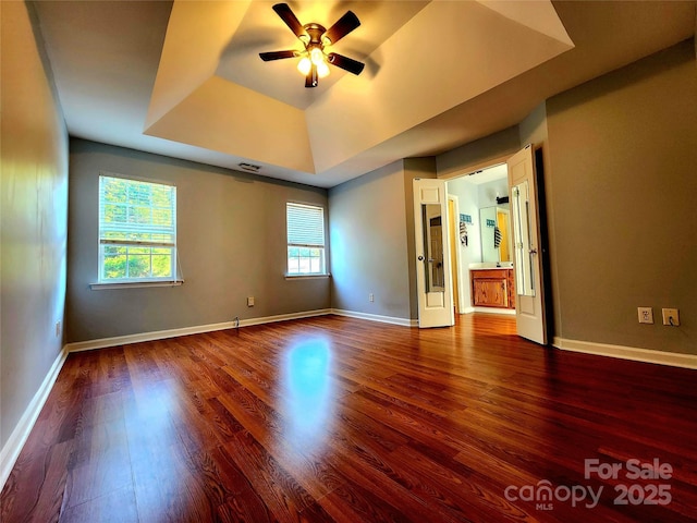 3108 Leicester Dr, Matthews, NC 28104 - spare room featuring a tray ceiling, ceiling fan, and dark wood-type flooring